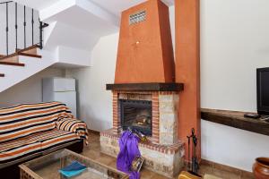 a living room with a fireplace and a couch at Casa Calera in Arbuniel