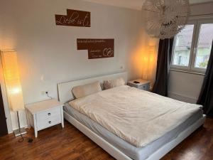 a bedroom with a white bed and a white night stand at Ferienwohnung Idylle in Wasserburg