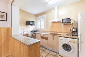 a kitchen with a washing machine and a washer at El Calderillo in Burgohondo