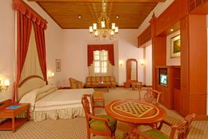 a bedroom with a bed and a table and chairs at KTDC Bolgatty Palace & Island Resort in Cochin