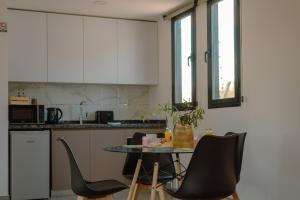 a kitchen with a table and chairs in a room at Lodwine Lodge Apartments in Ciudad Lujan de Cuyo