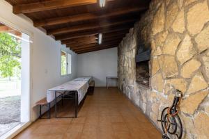 a room with a stone wall with a table in it at El Calderillo in Burgohondo