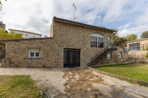 a stone house with a staircase on the side of it at El Calderillo in Burgohondo