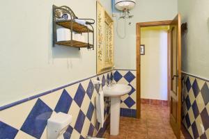 a bathroom with a sink and blue and white tiles at Rivero Rural in Rivero de Posadas +28 photos