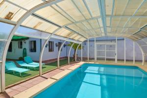 an indoor swimming pool with an arched ceiling at Rivero Rural in Rivero de Posadas
