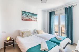 two beds in a room with a window at Casadeluxe Riquelme in Sucina +21 photos