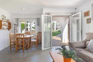a living room and dining room with a table and chairs at La Gardenia 41 in Es Castell