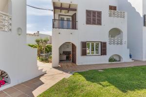 a white house with a patio and a yard at La Gardenia 41 in Es Castell