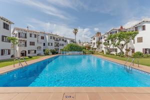 a swimming pool in front of some apartment buildings at La Gardenia 41 in Es Castell
