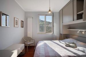 a bedroom with a bed and a window and a chair at Villa Vallegrande in Ospedaletti +25 photos