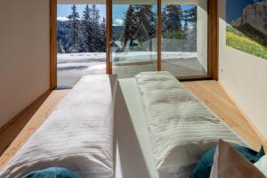 a room with two beds in front of a window at Chalet Magdalena und Lodges in Avelengo