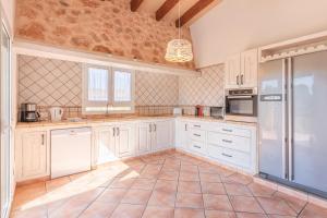 a kitchen with white cabinets and a tile floor at Villa Paqui in Portopetro