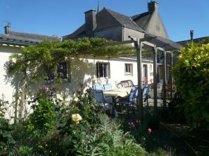 a house with a table and chairs in the garden at Le Rockin' Chair in Surzur