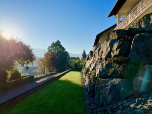 a stone wall next to a field of grass at Black Forest Brandenkopfblick in Zell am Harmersbach