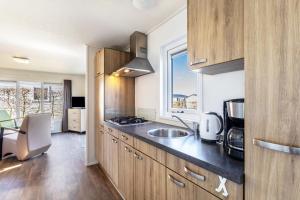a kitchen with wooden cabinets and a sink and a window at Chalet 91 in Brilon