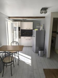 a kitchen with a table and chairs and a refrigerator at Studio Les Restanques in Montbrun-les-Bains +7 photos
