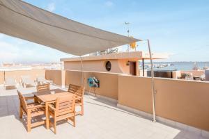 a balcony with a table and chairs on a ship at Ático deluxe Corralejo centro in Corralejo