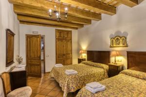 ein Hotelzimmer mit zwei Betten und zwei Stühlen in der Unterkunft Can Tapis in Santa María de Camós + 37 Fotos