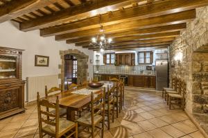 eine große Küche mit einem Holztisch und Stühlen in der Unterkunft Can Tapis in Santa María de Camós