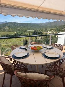 a table with a bowl of fruit and wine glasses at Duplex Botánico Resort in Estepona