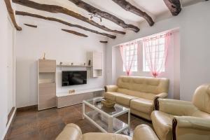 a living room with a couch and a tv at Casa Rústica in Vélez de Benaudalla