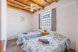 a bedroom with two beds and a window at Casa Rústica in Vélez de Benaudalla