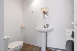 a white bathroom with a toilet and a sink at Casa Rústica in Vélez de Benaudalla +20 photos