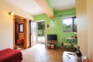 a room with a bed and a table with a television at Villa Casa Bianca Orange Apartment in Gaios
