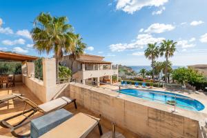 a villa with a swimming pool and palm trees at Pedrassa Gran Superior in Cala Santanyi