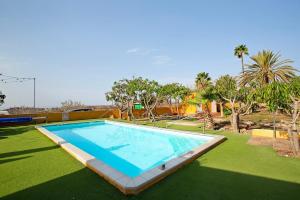 a swimming pool in a yard with grass and trees at Finca Vidalenta El Salobre in Salobre