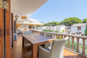 a deck with a wooden table and chairs on a balcony at Voramar Alcudia in Alcudia