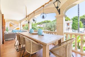 an outdoor patio with a wooden table and chairs at Voramar Alcudia in Alcudia