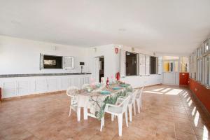 a dining room with a table and white chairs at Finca Vidalenta El Salobre in Salobre