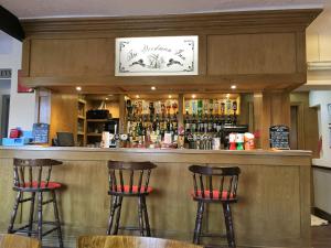 a bar with two bar stools in a restaurant at The Woodman Inn in Bedale