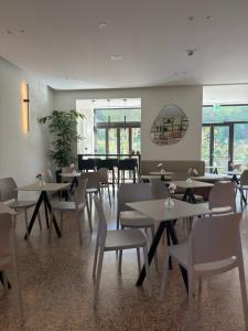 a restaurant with tables and chairs and a piano at Hotel Merloni in Grandola ed Uniti