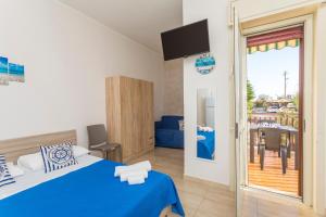 a bedroom with a blue bed and a balcony at Da Pina E Lu in Giardini Naxos