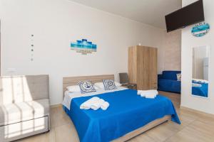 a bedroom with a blue bed and a blue couch at Da Pina E Lu in Giardini Naxos
