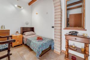 a small bedroom with a bed and a dresser at Casa rustica in Gonnesa