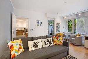 a living room with a gray couch with pillows at Stadt Land Fluss Plus in Arnsberg