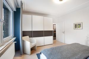 a bedroom with a bed and a chair and a window at Stadt Land Fluss Plus in Arnsberg