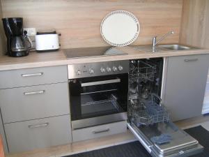 a kitchen with an oven with a sink and a dishwasher at Ferienwohnung Schwanbergblick in Mainbernheim