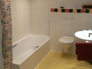a bathroom with a tub and a toilet and a sink at Ferienwohnung Schwanbergblick in Mainbernheim +19 photos
