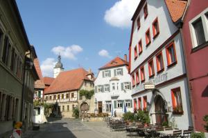a street in a town with buildings and tables and chairs at Ferienwohnung Schwanbergblick in Mainbernheim
