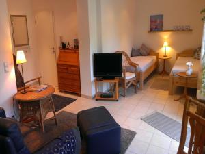 a living room with a room with a bed and a television at Ferienwohnung Schwanbergblick in Mainbernheim