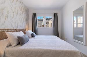 a bedroom with a large bed with two windows at Mangueros Suite 36 Puerto de Mogán in Puerto de Mogán +18 photos