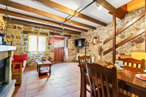 a kitchen and dining room with stone walls at Lorences A in Caunedo
