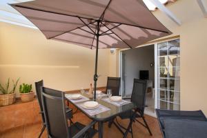 a dining room with a table with an umbrella at Mangueros Suite 36 Puerto de Mogán in Puerto de Mogán