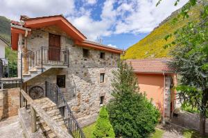 a stone house with a staircase and a hill at Lorences A in Caunedo +15 photos