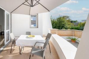 a table and chairs on a balcony with an umbrella at I 4 Venti in Melendugno