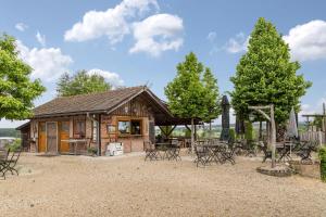 a log cabin with tables and chairs in front of it at Ferienwohnung Tipihof in Sauldorf